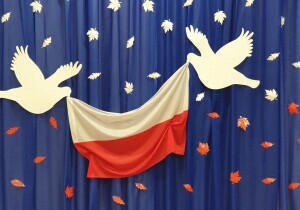 Zdjęcie flagi Polski i dw&oacute;ch gołębi wyciętych z kartonu.