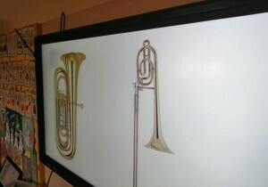 Zdjęcie tablicy multimedialnej. Na niej wyświetlane są instrumenty muzyczne.