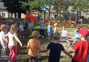Dzieci kręcą się w kole w ogrodzie przedszkolnym.