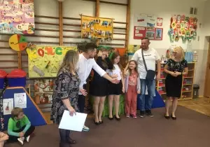 Pani Dyrektor, osoby prowadzące, absolwentki oraz ich tata stoją na środku sali.