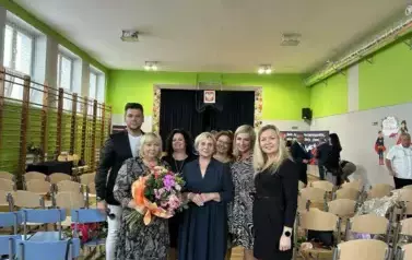 Nauczyciele z kwiatami i dyplomami