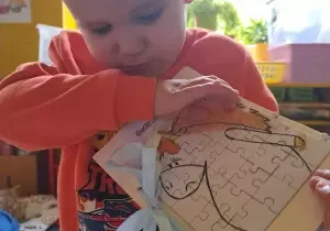 Chłopiec pokazuje książkę.