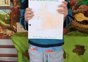 Chłopiec trzyma w ręku książkę samodzielnie wykonaną.