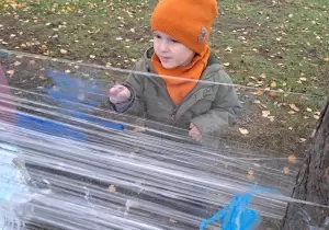 Chłopiec maluje pędzlem na streczu.
