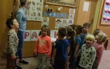 Dzieci słuchają nauczycielki opowiadającej o ich prawach.