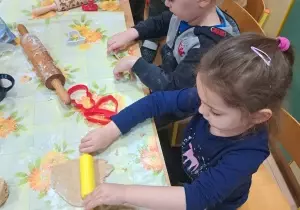Dziewczynka pokazuje ulepioną masę piernikową.