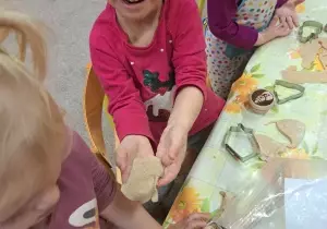 Dziewczynka pokazuje ulepioną masę piernikową.
