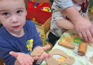 Chłopiec pokazuje ulepioną masę piernikową.