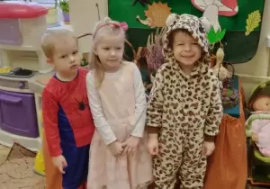 Tr&oacute;jka dzieci pozuje do zdjęcia. Dziewczynka przebrana jest za kr&oacute;lewnę, chłopiec za panterę, drugi chłopec za spidermana. 