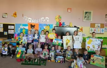 Zdjęcie grupowe dzieci z pracami plastycznymi.