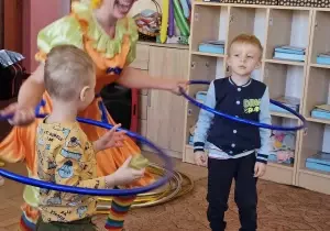 Dzieci kręcą na scenie kołami hula hop.
