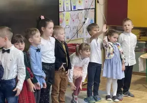 Dzieci odświętnie ubrane występują.