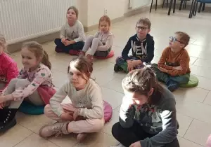 Dzieci siedzą na Kolorowych pufach.