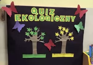Tablica z napisem quiz ekologiczny. Na tablicy przypięte dwa drzewa. Jedno ma zielone listki, drugie ż&oacute;łte listki.