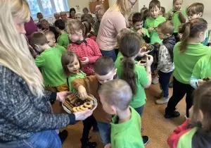 Nauczycielki rozdają dzieciom ciastka.