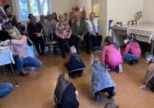 Dzieci występują w Domu Dziennego Pobytu Senior Vigor. Rozpoczynają taniec. 