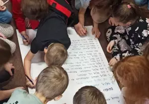 Dzieci podpisują się na kodeksie zachowania.