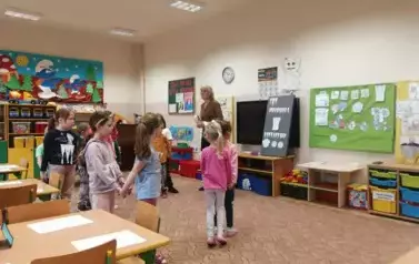 Dzieci podczas zabawy ruchowej z nauczycielem.