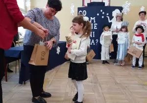 Dziewczynka odbiera nagrodę od Wicedyrektora Szkoły Podstawowej numer 8.