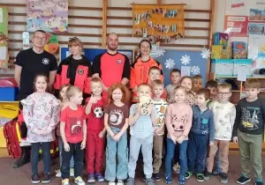Zdjęcie grupowe z ratownikami w sali przedszkolnej