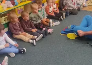 dzieci siedzą na dywanie
