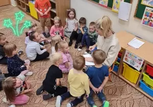 dzieci słuchają nauczycielki opowiadającej bajkę