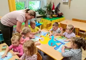 nauczycielka pokazuje dzieciom jaką pracę plastyczną mają wykonać