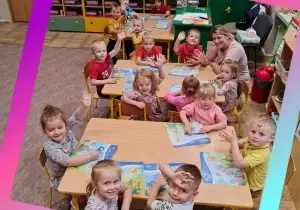 dzieci siedzą przy stoliku i lepią z plasteliny