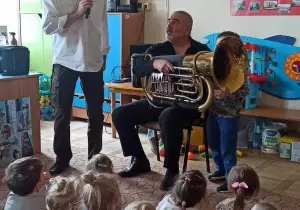 Pan trzyma tuba. Pan Witek stoi obok. M&oacute;wi przez mikrofon.