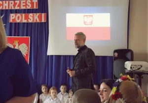 Zdjęcie Prezydenta Miasta Zgierza. Z tyłu za nim prezentacja multimedialna dotycząca Chrztu Polski.