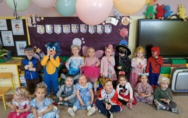 Dzieci stoją w grupie. Uśmiechają się. Przebrani są za r&oacute;żne postacie z bajek.