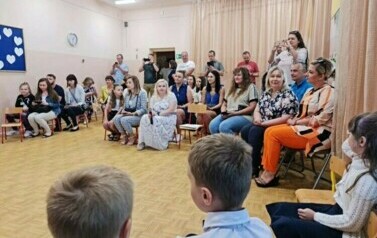 Pani dyrektor ,Pani wicedyrektor oraz rodzice uśmiechają się do dzieci. 