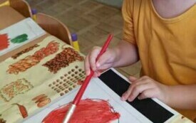 Dziewczynka maluje farbami .