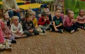 Dzieci siedzą w kole.