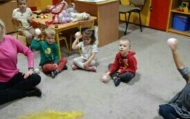 Dzieci siedzą na dywanie. 