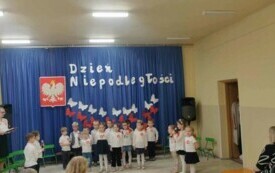 Dzieci stoją ,uśmiechają się .