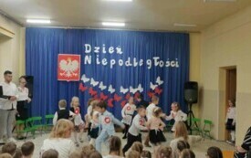 Dzieci tańczą taniec ludowy, uśmiechają się.