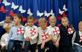 Dzieci stoją  przed dekoracją. 