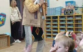 Indianin stoi na środku sali przedszkolnej.
