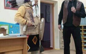 Indianin stoi w sali przedszkolnej. 