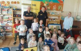 Dzieci stoją na zdjęciu widać znaki drogowe.