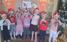 Zdjęcie grupowe. Grupa druga. Dzieci mają czapki mikołajkowe na głowach.