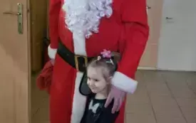 Święty Mikołaj stoi z dziewczynką.