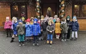 dzieci stoją przed domkiem Świętego Mikołaja