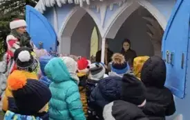 dzieci oglądają domek z bajki "Kr&oacute;lowa Śniegu"