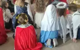 Dzieci siedzą i czekają na prezenty. 