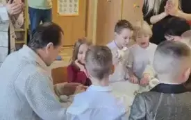 babcie i dziadkowie siedzą przy stoliku i obierają jabłko. 