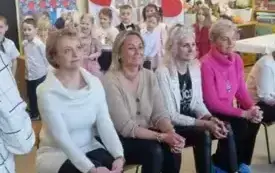 Babcie siedzą na krzesełkach . Uśmiechają się.