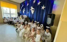 Dziewczynki przebrane są za aniołki. Uśmiechają się do zdjęcia.