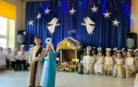 Na środku stoi dziewczynka i chłopiec. 